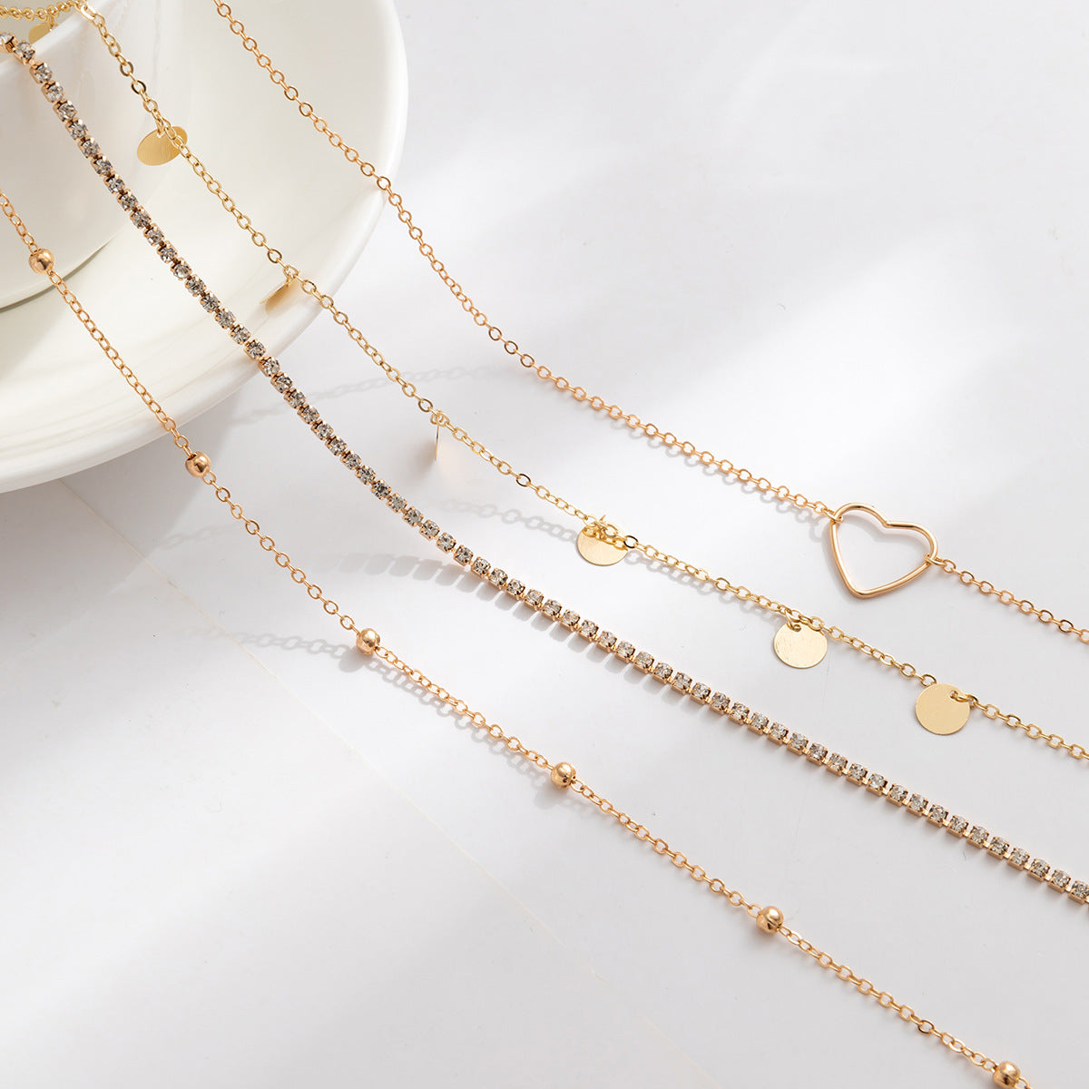 Ensemble de 4 chaînes de taille cœur et zircon. Argenté  et dorée